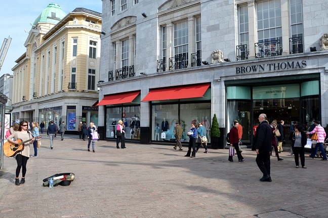 A Busker Performs in front of Brown Thomas Department Store in Cork City